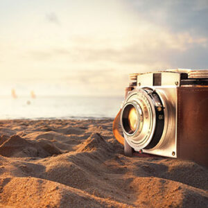 vintage-photo-camera-on-the-sand-at-the-beach